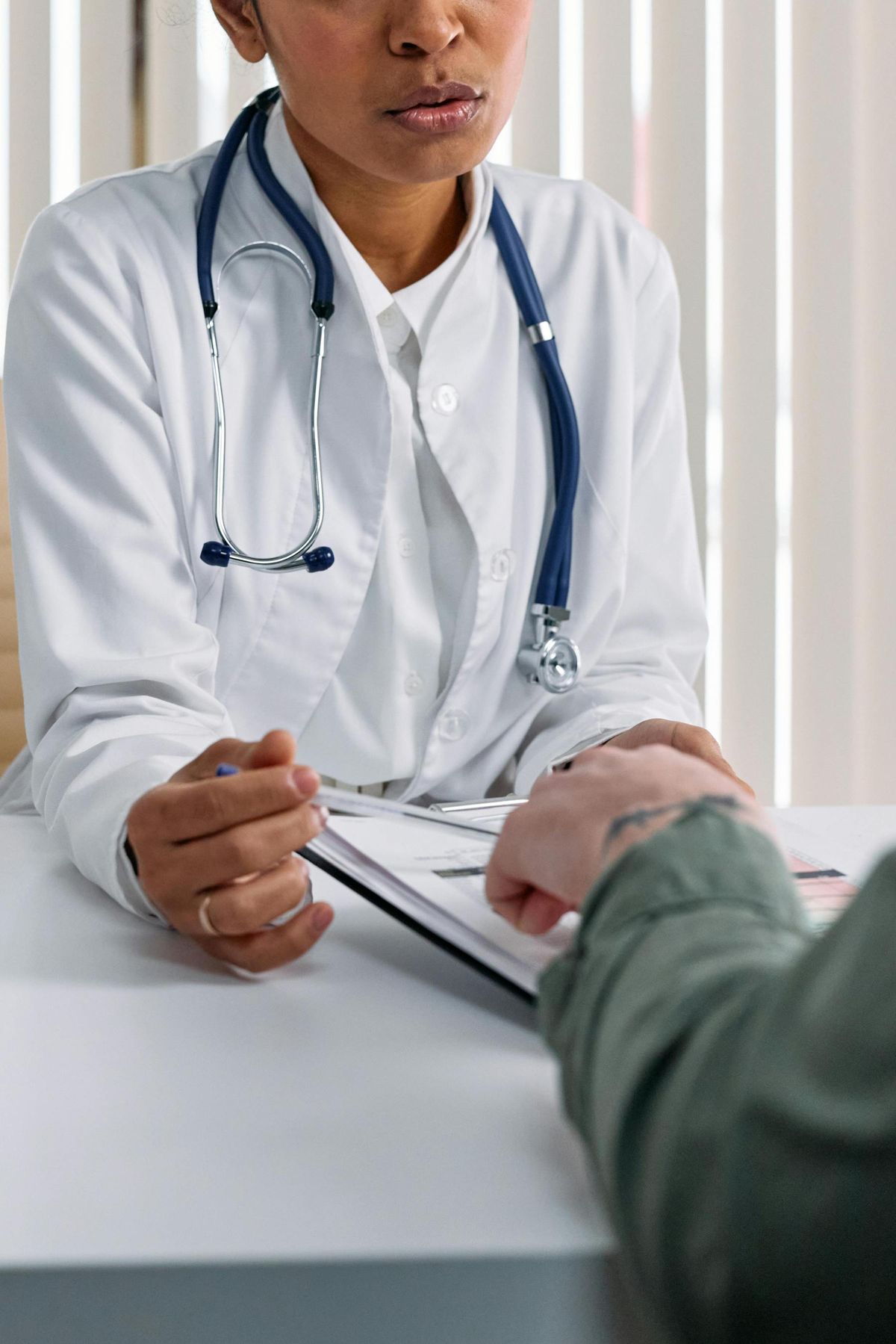 A doctor reassures a patient across a desk
