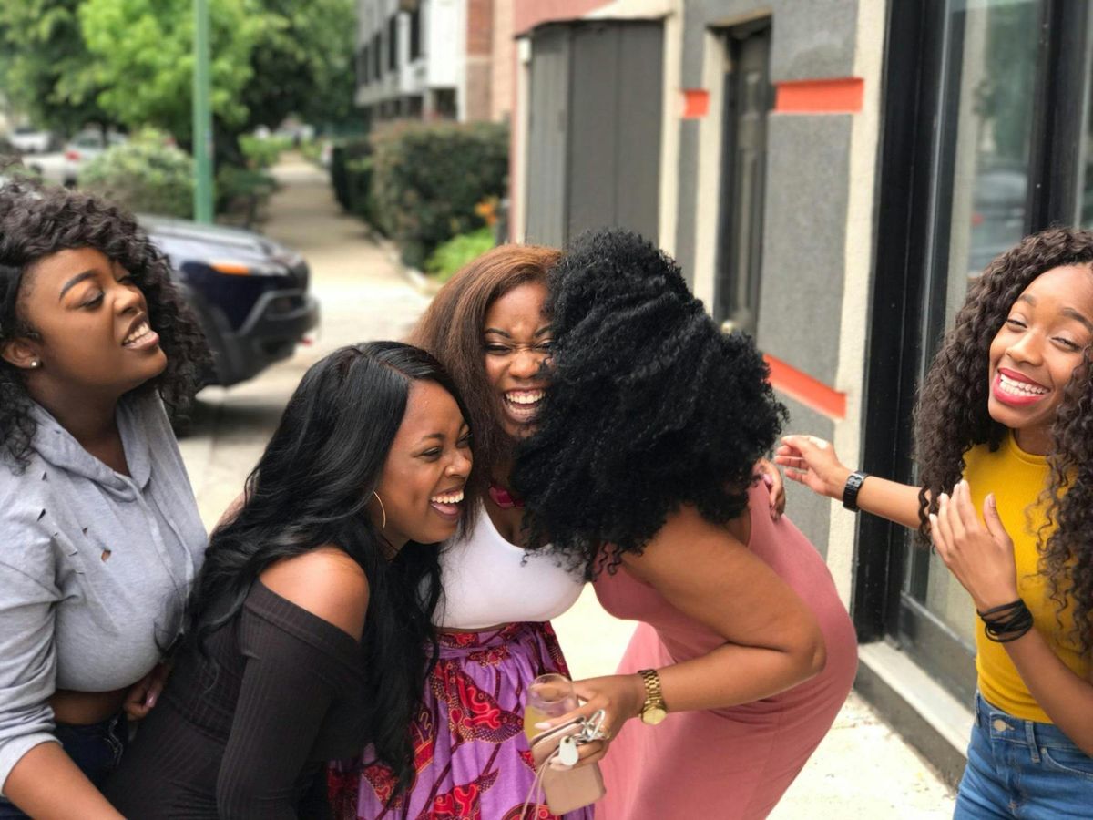 Friends laughing together on a city sidewalk
